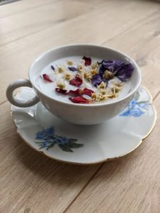 bougie fleurie dans une tasse de thé avec des fleurs séchées.